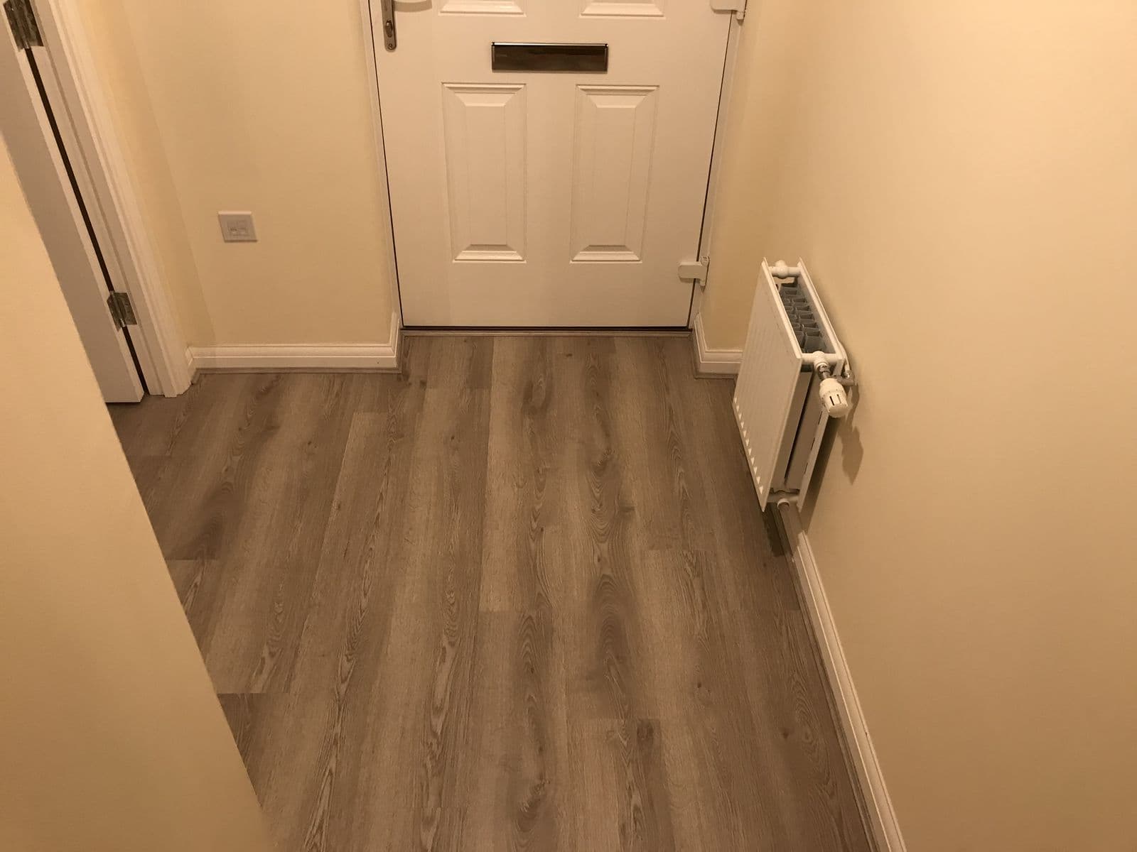 Oak-effect flooring laid through a hallway to the front door