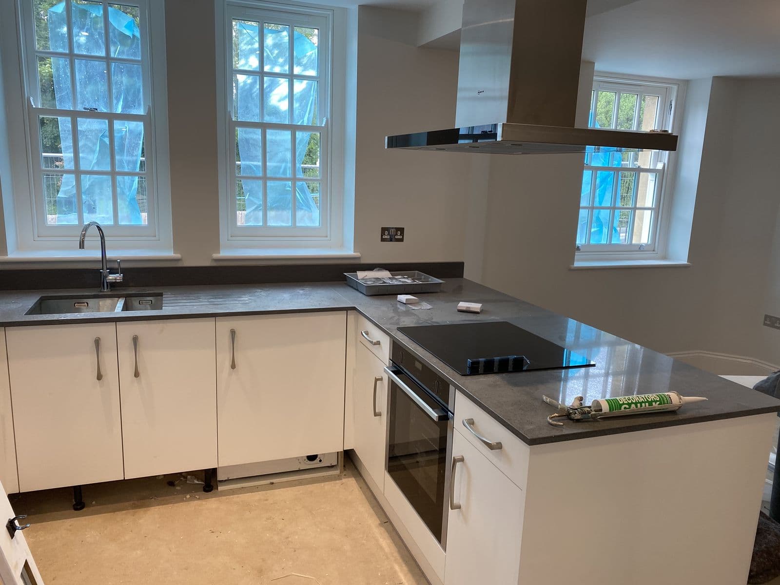 White kitchen units with dark worktop and inset sink